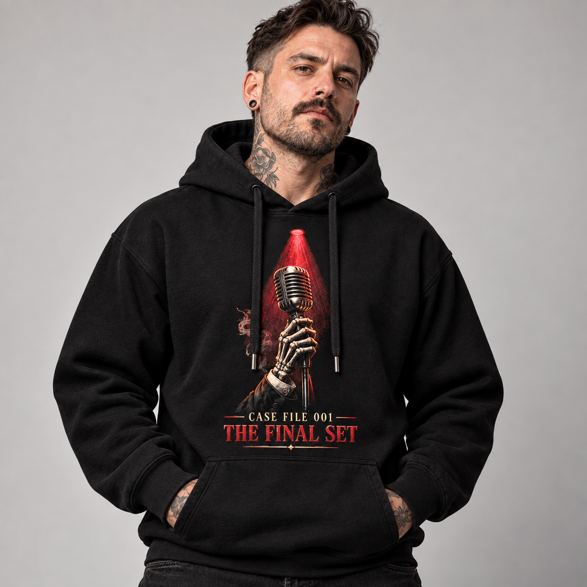 A man wearing a black pullover hoodie with a graphic print of a skeletal hand holding a vintage microphone under a red spotlight, with the text 'CASE FILE 001 THE FINAL SET' on the front, against a plain gray studio background.