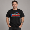 A man wearing a black short-sleeve graphic T-shirt with a red, white, and blue speedometer-style print reading 'ANALOGUE RESPONSE' on the chest, photographed against a plain gray studio background.