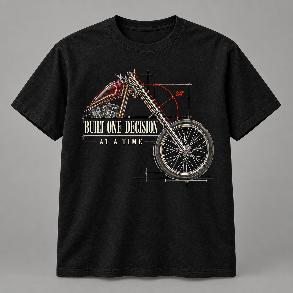 A black short-sleeve crewneck t-shirt featuring a technical blueprint-style graphic of a motorcycle with red and gold detailing, white text reading 'BUILT ONE DECISION AT A TIME', and red angle markings, shown on a neutral gray background.