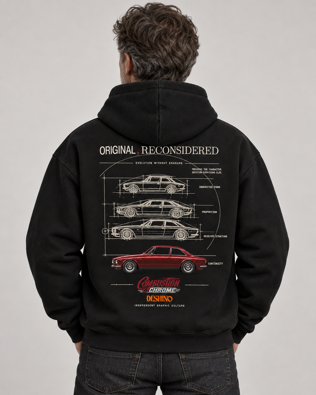 A man viewed from behind wearing a black hoodie with a large white car schematic graphic and a red car illustration on the back. The hoodie features the text 'ORIGINAL RECONSIDERED'.