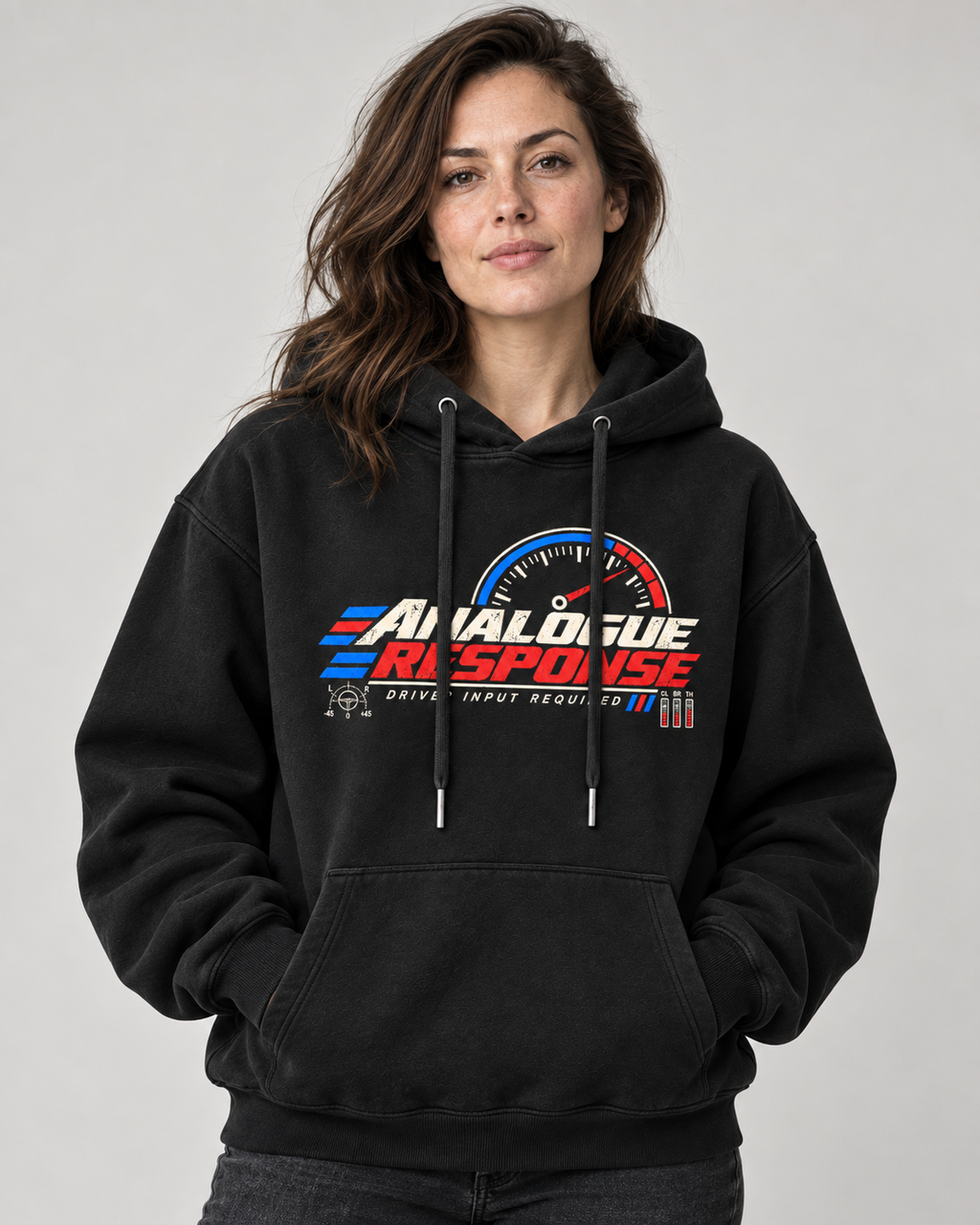 A woman wearing a black pullover hoodie with a 'Analogue Response' racing graphic on the chest, set against a plain light gray background.