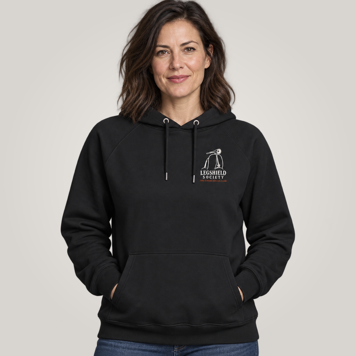 A woman wearing a black pullover hoodie with a white 'Legshield Society' logo on the left chest, set against a plain light grey background.