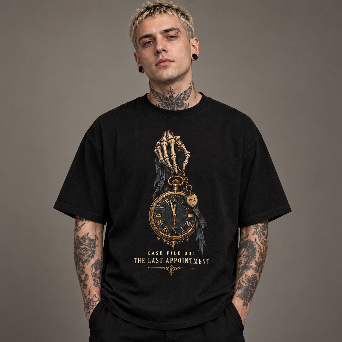 A man with tattoos wearing a black graphic t-shirt featuring a skeleton hand holding a pocket watch with the text 'CASE FILE 004 THE LAST APPOINTMENT'.